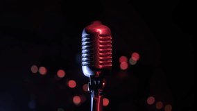 Retro microphone on stage against black background with lights close-up, camera moving closer to vintage mic. - Powered by Shutterstock - Get 15% off with code: PIKWIZARD15