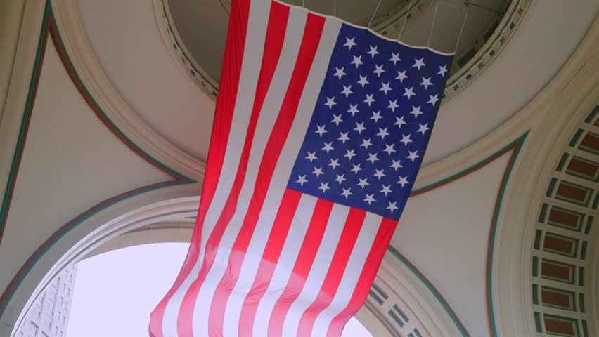 Large American flag hangs elegantly and proudly in an archway, showcasing the stars and stripes beautifully, symbolizing a deep sense of patriotism and national pride for all to see