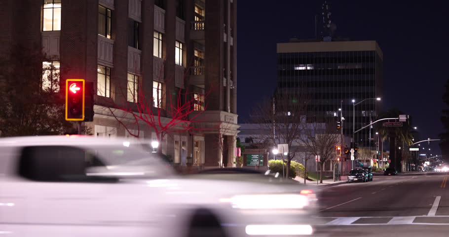 Evening traffic streams by the downtown skyline buildings of Bakersfield, California, USA.