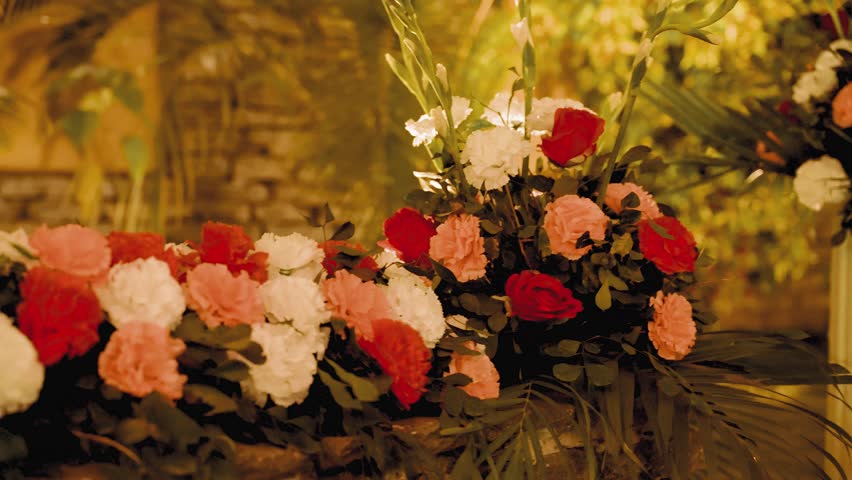 A colorful flower arrangement in red, white, and pink, flower with lush green foliage.