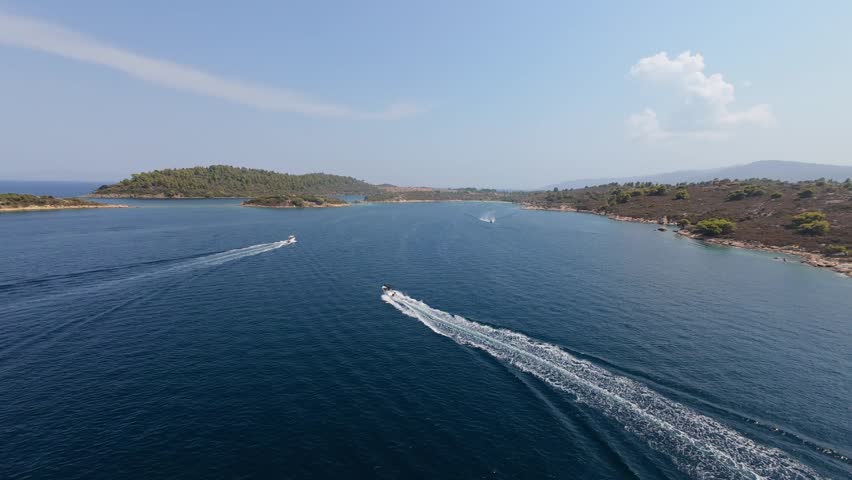 Speedboats navigating around a scenic Greek island