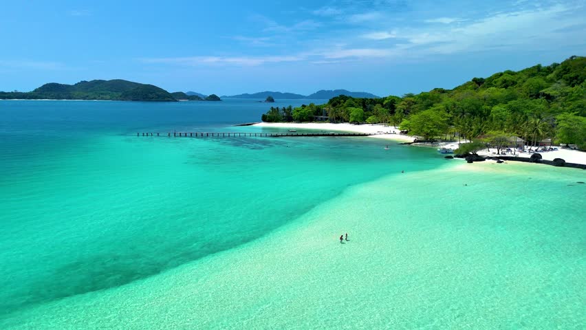 Experience the serenity of Koh Kham Island in Thailand, where soft white sands meet crystal-clear turquoise waters.