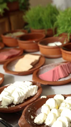 Hotel or restaurant buffet with variety of gourmet cheeses, cured meats and appetizers beautifully arranged on ceramic plates