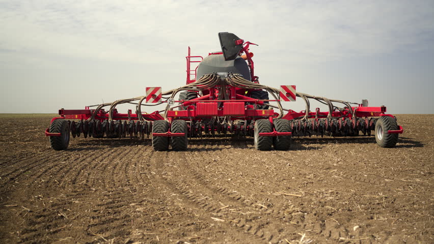 A modern air seeder stands in a field