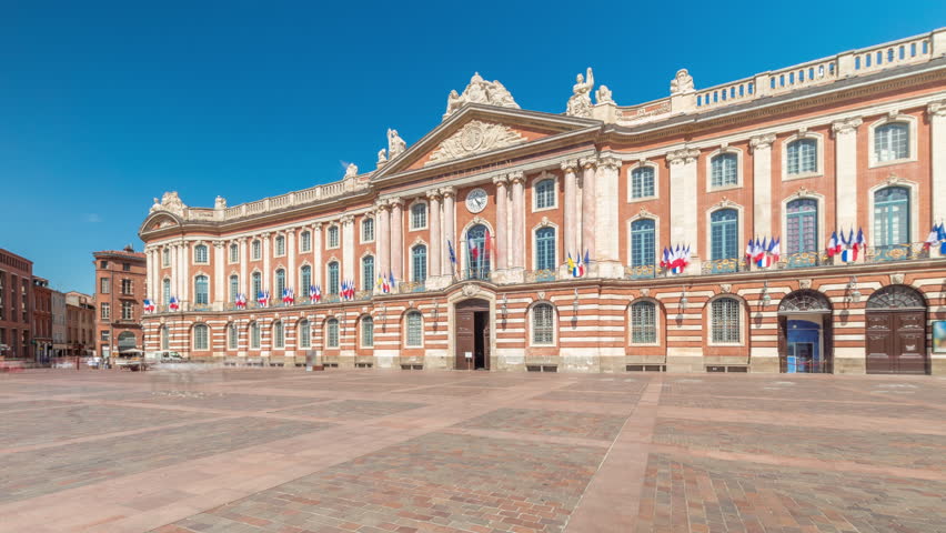 The Capitole de Toulouse facade timelapse hyperlapse showcases the historic city hall and municipal heart of Toulouse, France, located at Place du Capitole under a stunning blue sky