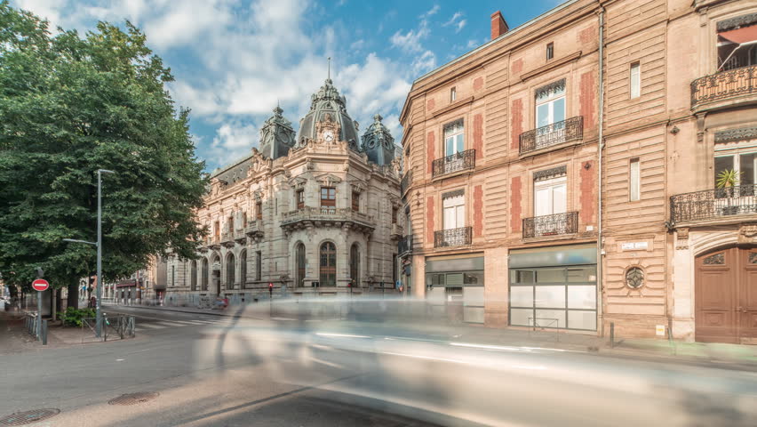 Panorama showing historic brick facades at Rue du Languedoc and Theodore Ozenne intersection timelapse in Toulouse, France. Shops, cafes, road traffic near Carmes metro station in vibrant city center