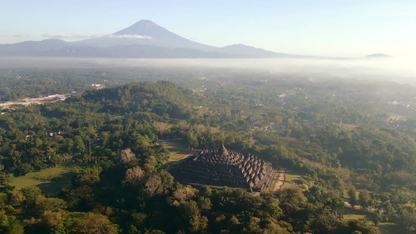 Aerial view of the majestic Borobudur Temple and Merapi volcano at sunrise near Yogyakarta, Indonesia