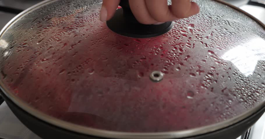 A dish of table beets is stewed in a frying pan. Vegetarian red dinner. Steam in the kitchen.