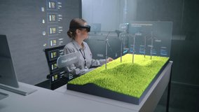 Futuristic Office: Female Engineer Uses Augmented Reality Headset to Visualize 3D Holographic Model of Wind Turbine on Wind Farm. Visualization of Artificial Intelligence Based Software Interface. - Powered by Shutterstock - Get 15% off with code: PIKWIZARD15