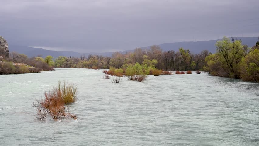 A swollen river. Floods in the spring. A lot of water flows in the river.