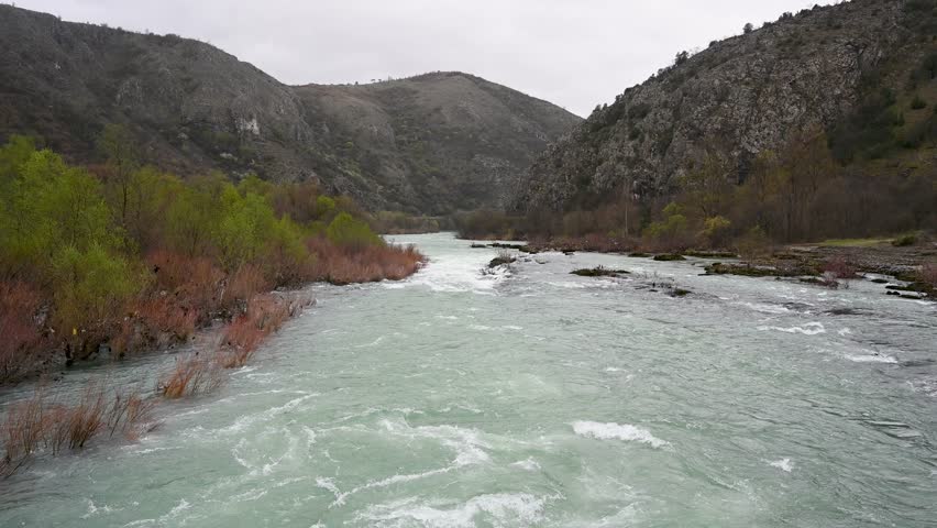 A swollen river. Floods in the spring. A lot of water flows in the river.