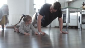 A joyful father and his daughter are doing push-ups together on the living room floor, creating family bonding time while staying active and promoting a healthy lifestyle. - Powered by Shutterstock - Get 15% off with code: PIKWIZARD15