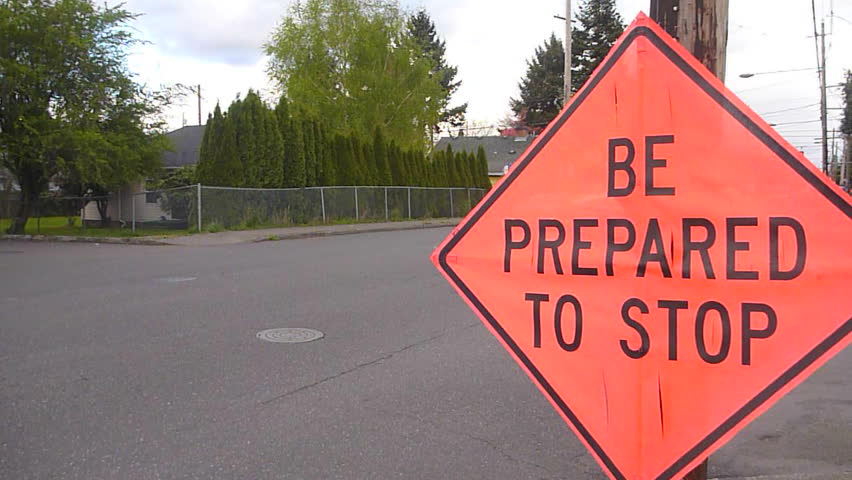 Road construction at intersection with traffic driving by and Be Prepared to