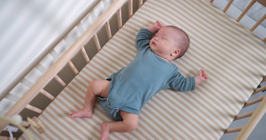 Newborn Baby Sleeping Peacefully in Baby Crib
