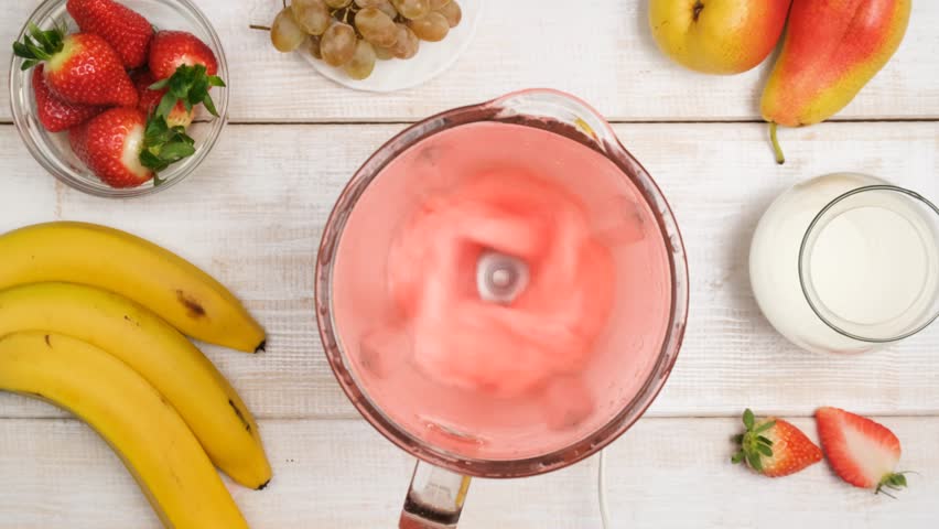 top view mixed fruit and berry cocktail with a blender. Grind fruits with berries using a blender and add milk. Healthy cocktail on a diet. Vegetarian drink from fresh organic ingredients. Smoothie