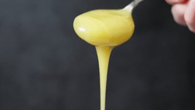 Extreme close up of honey dripping from a small spoon. Hand visible on the right side. Focus on the droplets falling down. Food close up and macro footage.  - Powered by Shutterstock - Get 15% off with code: PIKWIZARD15
