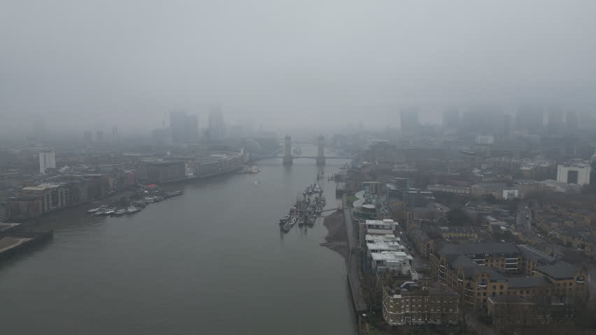Aerial footage of the iconic Thames River and Tower Bridge on a foggy day.
