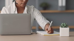 A woman is effectively teaching from home, using a laptop and notepad. She interacts with students remotely, demonstrating modern online education techniques. - Powered by Shutterstock - Get 15% off with code: PIKWIZARD15