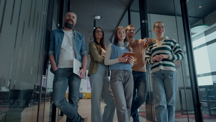 A diverse team of professionals in a modern coworking startup office smiles together, showcasing teamwork, collaboration, and a positive corporate culture that promotes innovation and a dynamic work