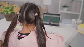 Asian young kid student learning online class with teacher at home. Adorable child student wearing headphones, using digital tablet study from school tutor by virtual remote online in living room. - Powered by Shutterstock - Get 15% off with code: PIKWIZARD15