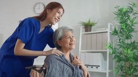 Asian caring caregiver look after senior woman patient at nursing home. Elderly grandmother in wheelchair receiving physical therapy with support from female nurse therapist during the therapy session - Powered by Shutterstock - Get 15% off with code: PIKWIZARD15