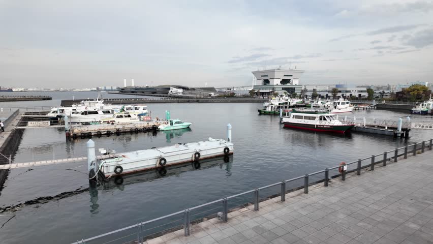 Yokohama , Japan - 03 28 2025: Boats resting in Yokohama harbour on a cloudy day