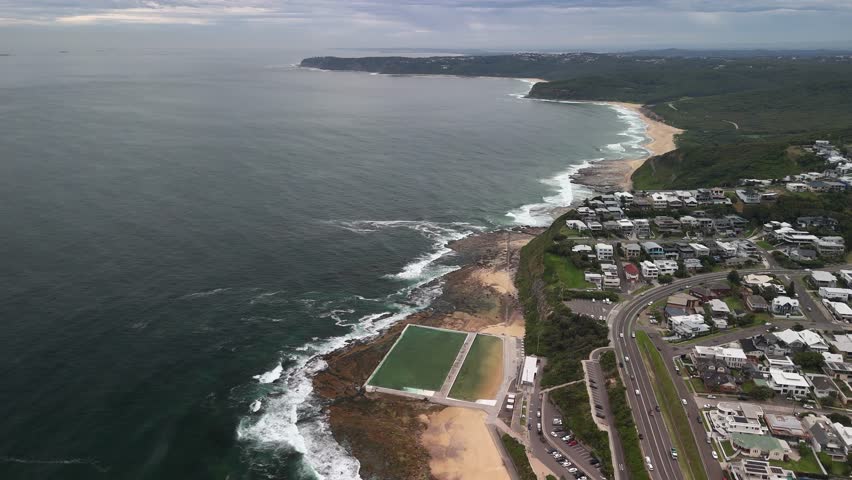 Grey overcast aerial view of Mereweather pools on beach, NSW Australia
