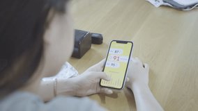 A person monitors their health metrics using a smartphone app. The screen shows various readings, contributing to personal wellness awareness and health tracking. - Powered by Shutterstock - Get 15% off with code: PIKWIZARD15