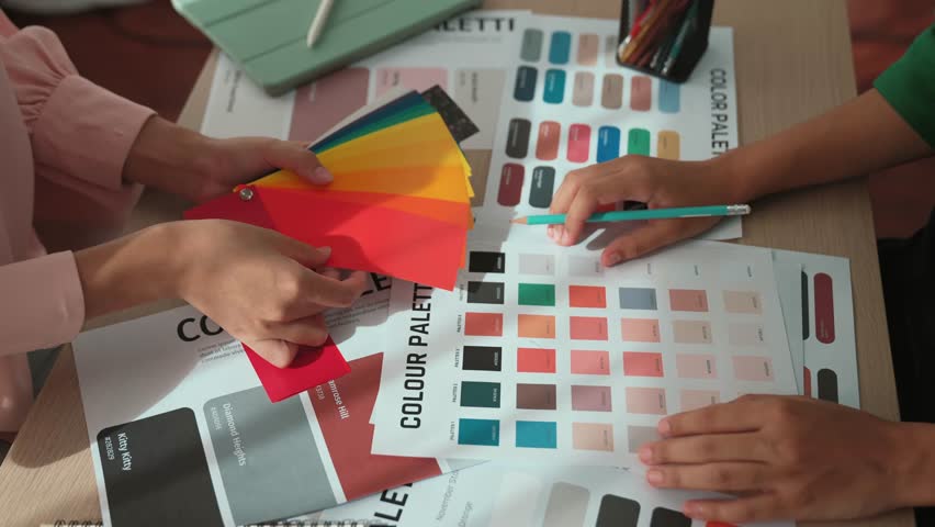 Slow motion hand closeup of two designer brainstorming and choosing color for graphic design working or client asking advise with chromatic consultation at designer agency office. Variegated