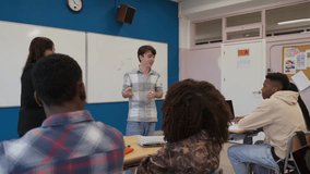 Student presenting in classroom with engaged audience and teacher - Powered by Shutterstock - Get 15% off with code: PIKWIZARD15