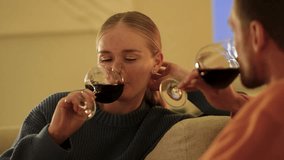 Blushing smiling woman sips red wine during cozy evening date on comfortable couch. Romantic couple shares tender conversation, romance and first meeting, exchanging loving glances, tender couple - Powered by Shutterstock - Get 15% off with code: PIKWIZARD15