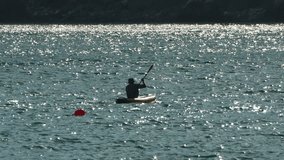 A Man Kayaking on a Sparkling Lake on inflatable kayak - Powered by Shutterstock - Get 15% off with code: PIKWIZARD15