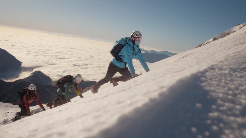 Group of adventurous climbers ascends a snowy peak, their determination and camaraderie evident in the dynamic, low-angle shot.