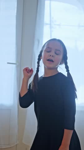 A Joyful and Cheerful Child Engaging in Dance While Wearing a Beautiful Black Dress