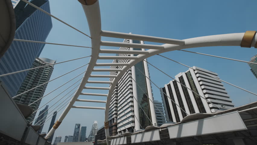 Chong Nonsi Skywalk - pedestrian walkway bridge arch and skyscrapers in the downtown Central Business District in Bangkok, Thailand, 4k