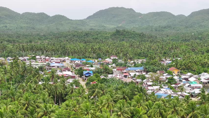 Filipino village by the river surrounded by palm trees, province in Siargao Island, Philippines.