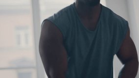 Muscular African American man performing kettlebell swings during intense workout in home gym - Powered by Shutterstock - Get 15% off with code: PIKWIZARD15