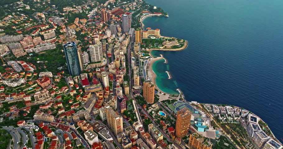 Aerial view of the city center of Monaco. Establishing shot showcases luxury yachts moored in Monaco Bay, the Palais Princier de Monaco, and luxury apartment buildings of Monte Carlo