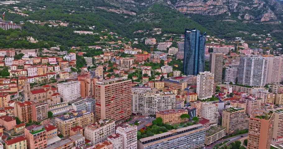 Aerial view of the city center of Monaco. Establishing shot showcases luxury yachts moored in Monaco Bay, the Palais Princier de Monaco, and luxury apartment buildings of Monte Carlo