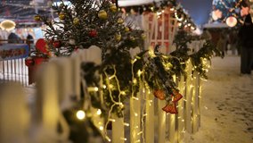Christmas lights and decorations adorning a white picket fence at a winter festival - Powered by Shutterstock - Get 15% off with code: PIKWIZARD15