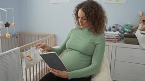 Pregnant woman reading book in cozy nursery with crib and toys enhancing peaceful ambiance. - Powered by Shutterstock - Get 15% off with code: PIKWIZARD15