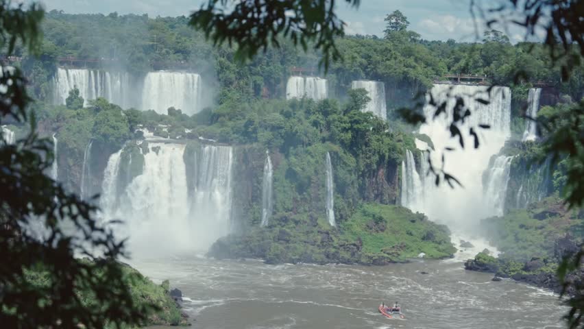 Panoramic view of Iguazu Falls from the Brazilian side with a wooded landscape.