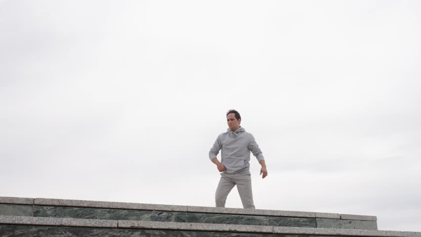 Parkour athlete performing acrobatics on building ledge - Powered by Shutterstock - Get 15% off with code: PIKWIZARD15
