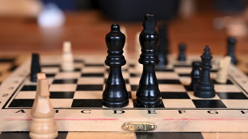 Chess pieces on a chessboard. Playing chess. Strategic game.  Black King and queen in first plan. 