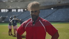 Rugby player in red jersey standing with teammates huddling on field. Sports, teamwork, athletes, huddle, competition, outdoors - Powered by Shutterstock - Get 15% off with code: PIKWIZARD15