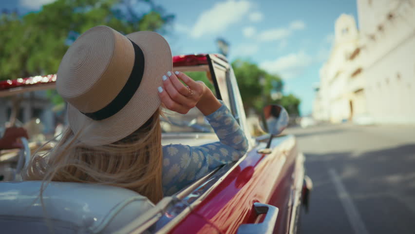 Summer traveling by car, blonde woman sitting on passenger seat in cabriolet. Portrait of happy lady smiling and looking around, sightseeing and tourist excursion, carefree lifestyle and happiness