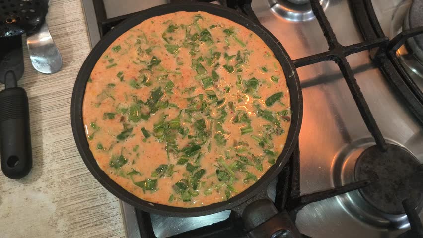 omelette in a frying pan. omelette with herbs. home cooking. eggs in a frying pan. fried eggs with herbs.