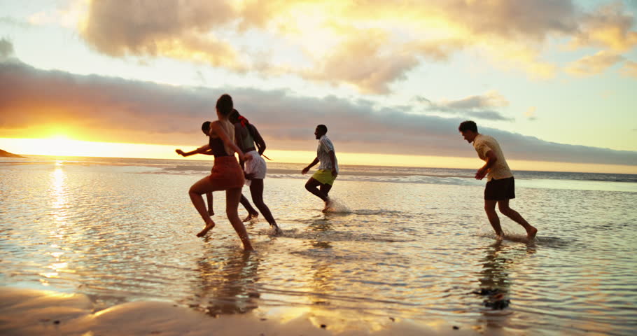 Holiday, sunset and friends running on ocean water for adventure, fun and bonding together with energy. People, sea race and group on trip outdoor at beach for summer vacation, travel and freedom