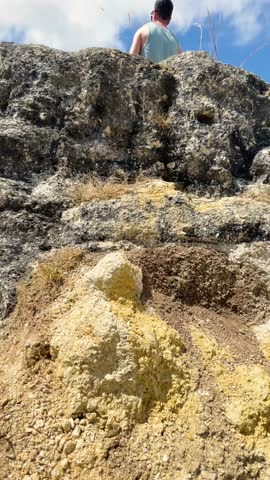Man standing at Te Mata Peak with scenic view of rolling hills and bright skies