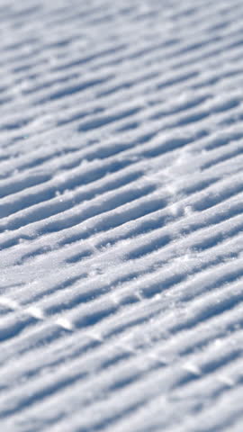 Close up of lines on the snow prepared for skiing on the mountain in the Dolomites, Italy. Vertical